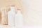 Soft elegant home decor with white bottles and beige twigs on white wooden board.