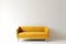 soft empty yellow sofa stands on white isolated background, comfortable fabric couch is alone against the background of white wall