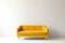 soft empty yellow sofa stands on white isolated background, comfortable fabric couch is alone against the background of white wall