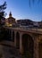 Soft evening light of lanterns illuminates narrow stone bridges of town Cenicero