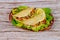 Soft flour tortillas stuffed with lettuce, meat and cheese on wooden background