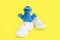 Soft fluffy children`s toy cookie monster in white shoes sneakers on a yellow background