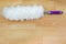 Soft fluffy white furry feather static duster with purple handle