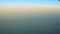 Soft focus aerial view from airplane window on green land with white fog