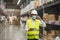 Soft focus asian engineer or technician wearing mask,safety hard hat,uses digital tablet check merchandise stock,security cargo