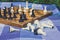 Soft focus classic chess desk on background and black and white falling figures on foreground in blue carpet texture copy space