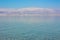 Soft focus Dead sea peaceful coast line landscape scenic view calm water surface foreground and Jordanian mountains in fog