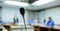 Soft focus of desktop wireless Conference microphones with blurry business group in a meeting room, microphone on the desk in