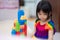 Soft focus. Girl play with colorful plastic blocks. Child play alone. Children play house activities.