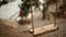 Soft focus image of the empty swing in the garden. wooden swing on the old rope sways in the light wind