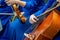 Soft focus photo. Women in blue costumes play cello and violin