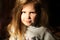 Soft focus portrait of serious little girl isolated on black background