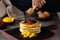 Soft focus of a stack of fluffy pancakes with fresh fruits and honey on a wooden board