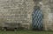 Soft focus stone castle wall background with iron arch shape door and empty bench European landmark