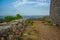 Soft focus stone walls of ancient medieval castle ruins on top of rock in highland mountain landscape environment