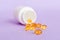 Soft gels pills with Omega-3 oil spilling out of pill bottle close-up. Gel capsules bottle white surface. Omega 3