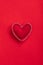 Soft handmade felt heart on red background