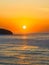 Soft hazy sunrise seascape with full sun and orange horizon