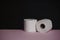 Soft hygienic white toilet paper on black pink background