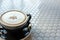 Soft milk foam above the coffee cup with a black saucer on the table