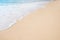 Soft ocean wave on tropical sandy beach in summer background with copy space