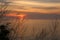 Soft panorama seascape shot of a beautiful red orange sunset on a purple pink cloudy sky with beautiful golden reflection of light