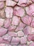 Soft pink stone wall with natural cracks and varied textures.