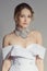 Soft portrait of beautiful bride in concept wedding dress. Jacket-style collar and deep decollete, plume and stockings