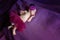 Soft portrait of peaceful sweet newborn infant baby lying on bed while sleeping in purple blanket