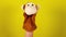 Soft puppet toy on hand on yellow background. Concept of puppet show. Close-up of hand with puppet monkey.