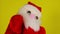 Soft puppet toy of santa claus on hand nodding head. Close-up of santa claus puppet on yellow background. Concept of