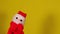 Soft puppet toy of santa claus on hand. Santa claus puppet on yellow background. Close up. Concept of puppet show and