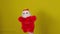 Soft puppet toy of santa claus on hand. Santa claus puppet on yellow background. Close up. Concept of puppet show and