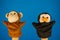 Soft puppet toys on hands on blue background. Concept of puppet show. Close-up of hands with puppet monkey and penguin.
