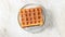 Soft rectangular waffles are spinning on a saucer. Delicious dessert.