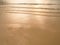 Soft sea wave sand beach at sunset / sunrise. Orange color of sea water surface reflect with sunset. Summer an recreation concept