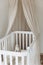 Soft sheep toy on beige cocoon, baby nest for newborn over cribs in nursery. Childhood concept. Eco-friendly safe