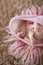 Soft sleeper newborn girl in pink on beige wool