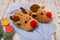 Soft slippers-deer on a blue sweater, spruce branch, citrus fruits and a garland on a wooden background