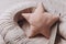 Soft star pillow toy on beige cocoon, baby nest for newborn over cribs in nursery. Childhood concept. Eco-friendly