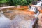 Soft streamlet falling on layers of sandstone, art shape of stones pool and surface of freshwater