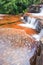 Soft streamlet falling on layers of sandstone, art shape of stones pool and surface of freshwater