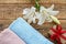 Soft terry towels with lily flower on wooden background