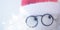 Soft toy abstract Santa Claus face with glasses and red hat, closeup eyes