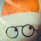 Soft toy abstract Santa Claus in red hat, closeup eyes in black round glasses