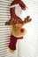 Soft toy deer with horns hang on the window handle with jalousie. New Year`s Eve