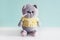 Soft toy knitted cat. Grey plush british fold cat in a yellow t-short on blue background