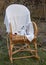 A soft toy mouse, a book and a knitted blanket on a wicker rocking chair