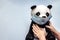 Soft toy panda in a disposable medical mask in children`s hands. Coronavirus epidemic concept. Personal hygiene for kids