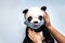 Soft toy panda in a disposable medical mask in children`s hands. Coronavirus epidemic concept. Personal hygiene for kids